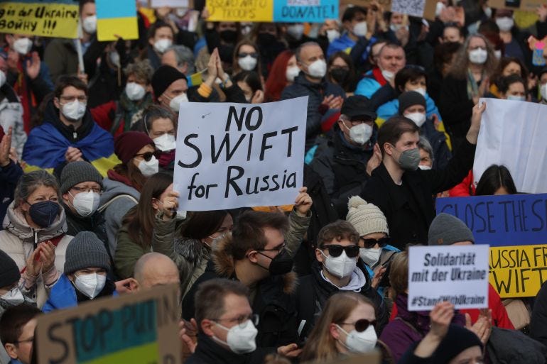 A protester holds a placard reading "No SWIFT for Russia" during a rally against Russia's invasion of Ukraine on February 26, 2022, in Frankfurt am Main, western Germany. (Photo by Yann Schreiber / AFP) A protester holds a placard reading "No SWIFT for Russia" during a rally against Russia's invasion of Ukraine on February 26, 2022, in Frankfurt am Main, western Germany. (Photo by Yann Schreiber / AFP)
