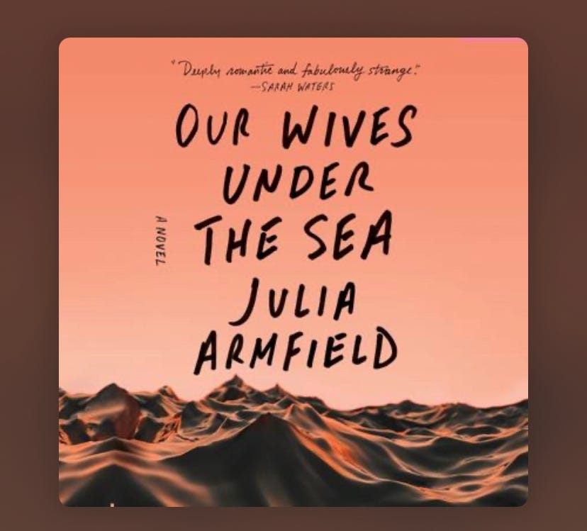 Cover of Our Wives Under the Sea by Julia Armfield featuring a pale orange sky above choppy sunset lit open ocean, featuring the title of the novel in handwritten capital letters