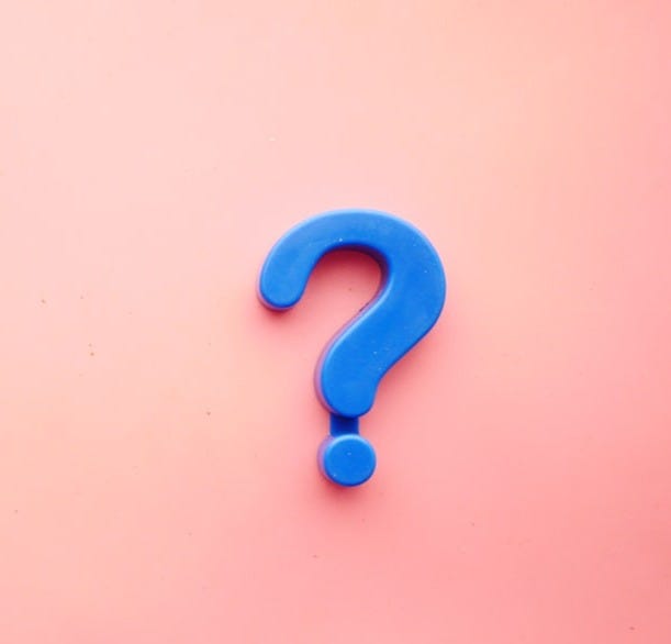 a blue question mark on a pink background