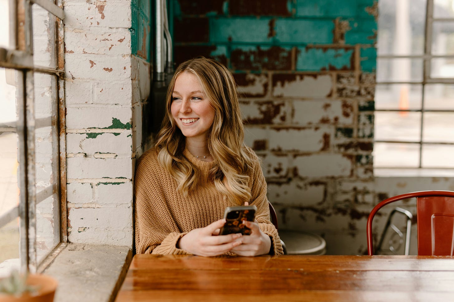A writer smiles as she reads from her mobile phone