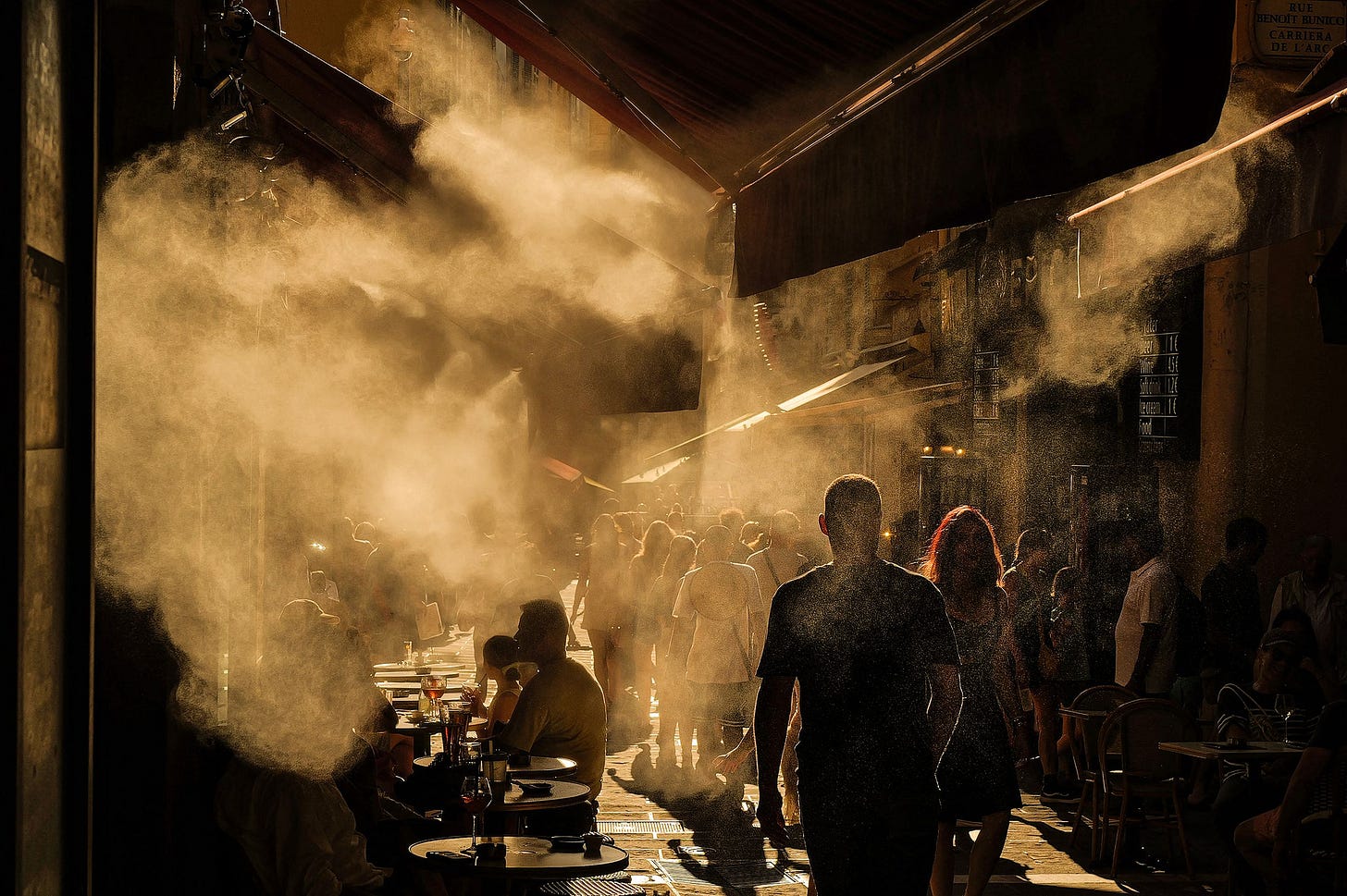 Figures walk through a crowed steamy street
