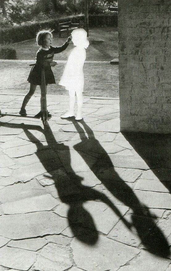 This may contain: the shadow of two children holding hands