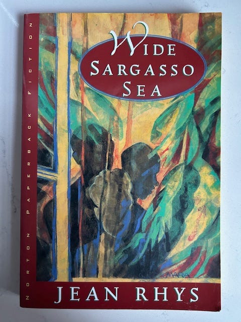 The cover of Wide Sargasso Sea has abstract figures on the cover. A red oval shape is overlaid by the title. The cover of Wide Sargasso Sea has abstract figures on the cover. A red oval shape is overlaid by the title.