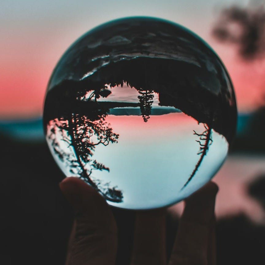 person holding clear crystal ball