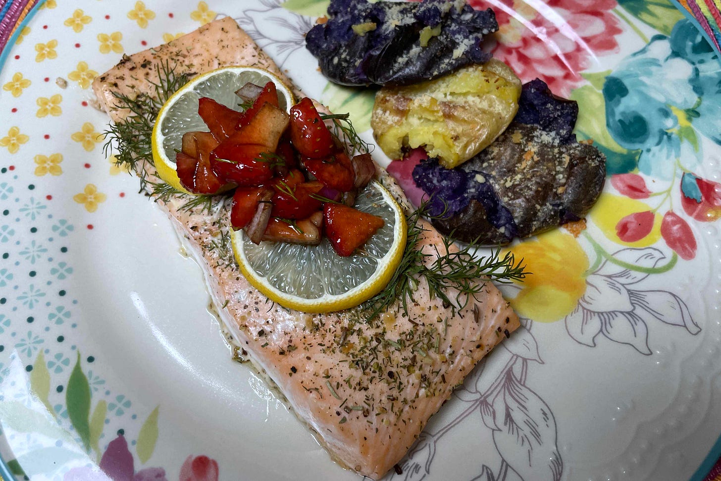 baked salmon filet on a plate with baby potatoes