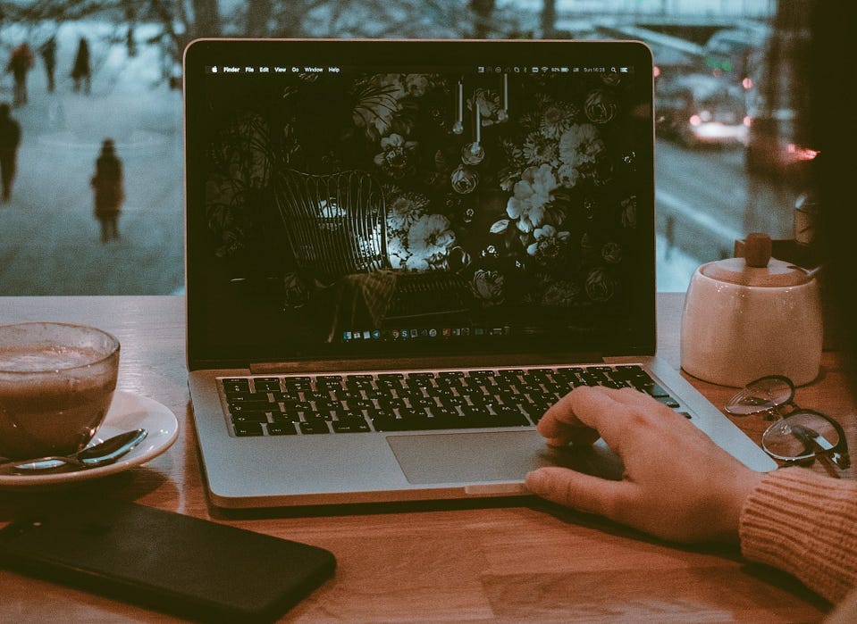 Image of a person using laptop in a cafe