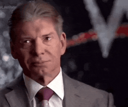 a man wearing a suit and tie is looking at the camera