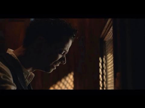 A handsome young man weeping in a Catholic confessional