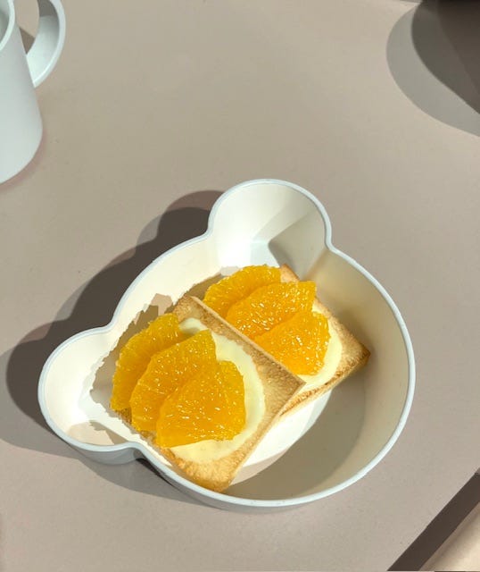on the right is a plate with three replica mandarins and two halves, and on the left is an example of fake food described as orange slices on pizza