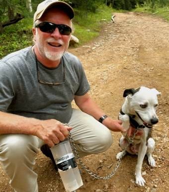 A person squatting on a dirt path with a dog

AI-generated content may be incorrect.