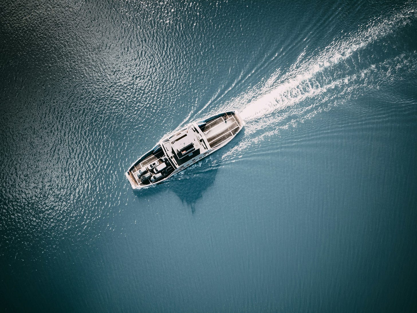 white and brown boat on blue sea water during daytime