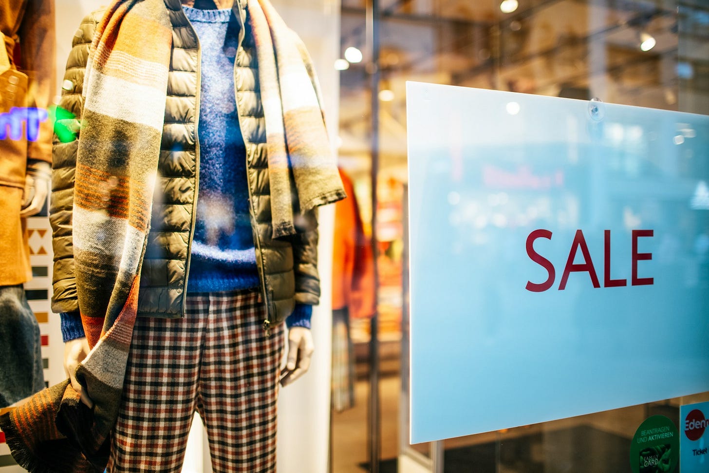 Mannequin next to a Sale sign in a store window. Photo by Markus Spiske on Unsplash