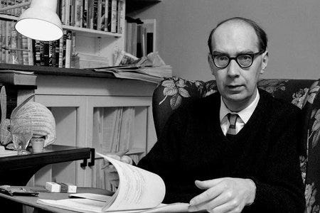 Photograph of the poet Philip Larkin at his desk.