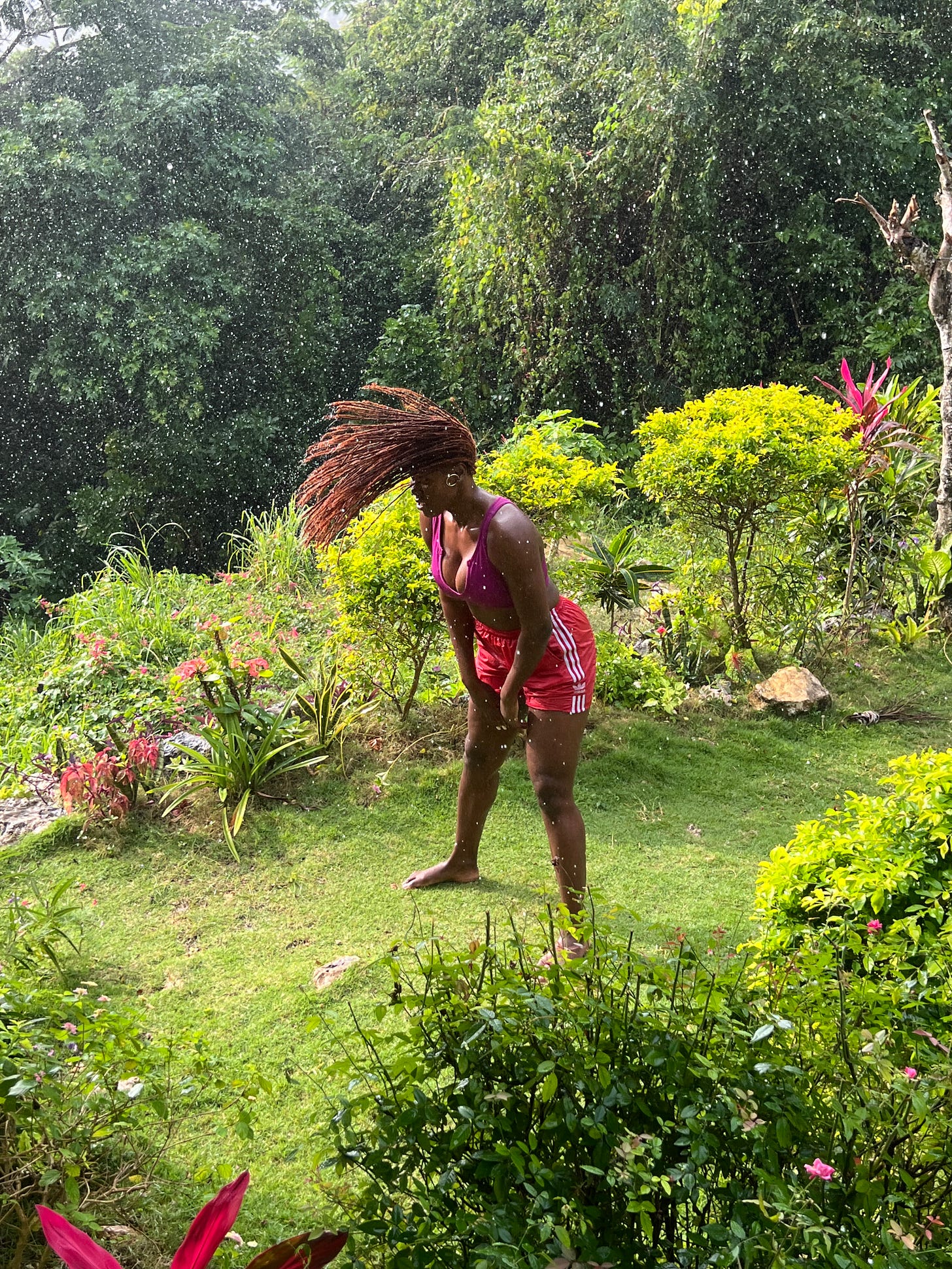 woman playing in rain in the countryside of Jamaica