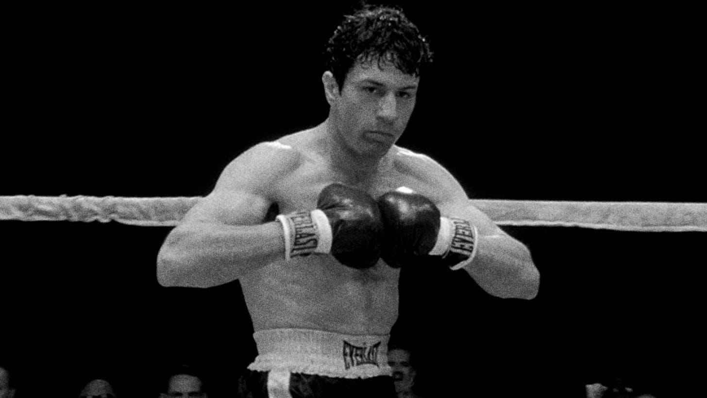 Raging Bull | Still features Robert De Niro as Jake LaMotta with boxing gloves on, pressed against each other.