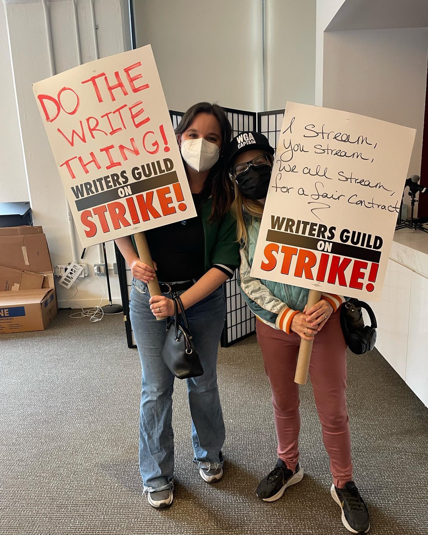 Dos miembros del WGA East (la sede del sindicato de guionistas en Nueva York) posan con sus carteles listas para una posible huelga. Dos miembros del WGA East (la sede del sindicato de guionistas en Nueva York) posan con sus carteles listas para una posible huelga.