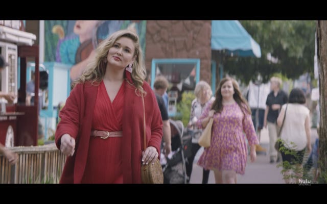 Woman in red jumpsuit in foreground, Aidy Bryant in background, from 'Shrill' Woman in red jumpsuit in foreground, Aidy Bryant in background, from 'Shrill'