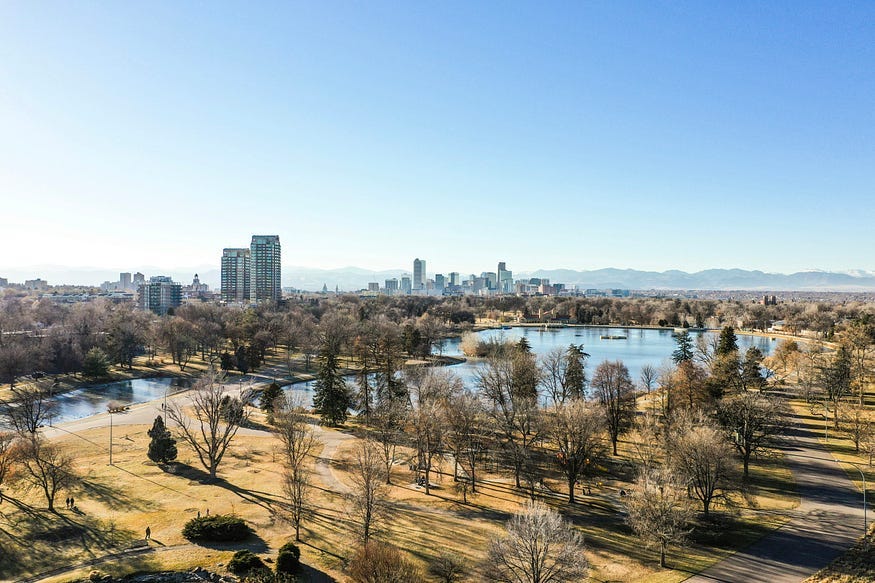 A beautiful city park, laid out around a small pond near the shores of a great river. This autumnal green space, combined with public transportation, could greatly improve the environment.