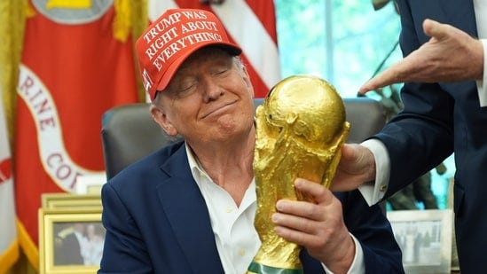President Donald Trump holds the FIFA World Cup Winners Trophy during an announcement in the Oval Office (AP)