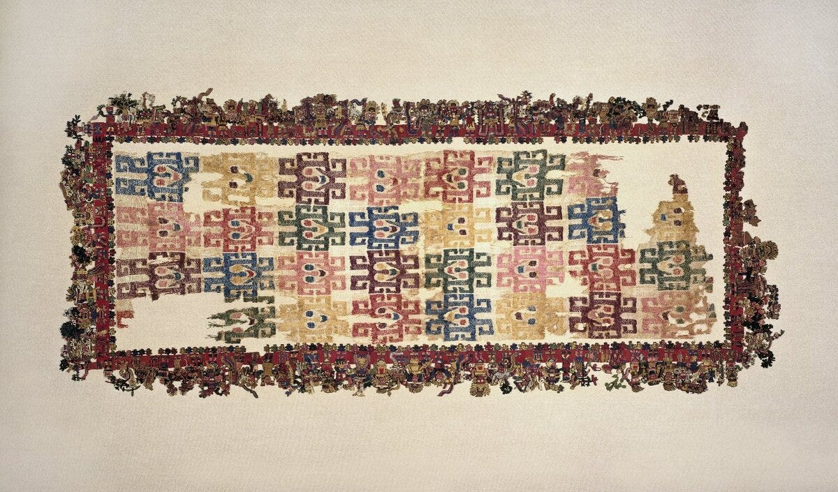 A rectangular pre-Columbian textile with a repeating geometric design. The fabric appears aged and fragile and is displayed flat against a neutral background. Mantle (“The Paracas Textile”), 100–300 C.E. – via [Wikimedia](https://en.wikipedia.org/wiki/Textile_arts#/media/File:Nasca._Mantle_(%22The_Paracas_Textile%22),_overall.jpg)
