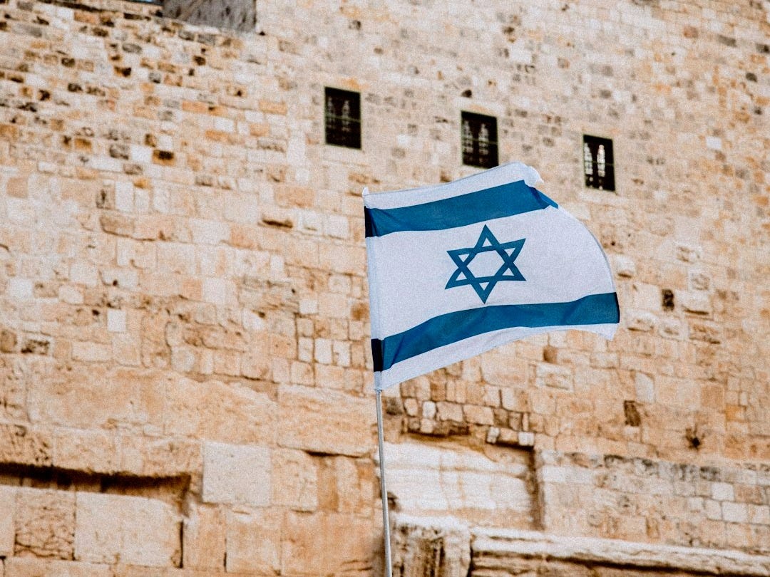a flag flying in front of a stone building a flag flying in front of a stone building