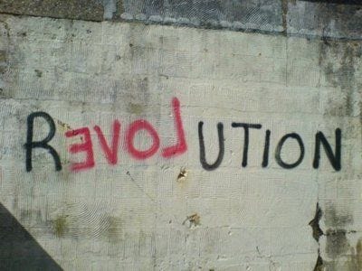 This may contain: graffiti on the side of a building that says revolution written in black and red spray paint