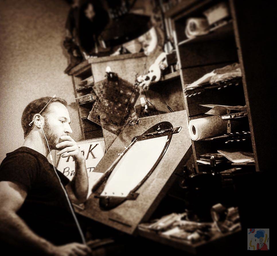 Man with pencil behind his ear stares at a blank page on drawing table.