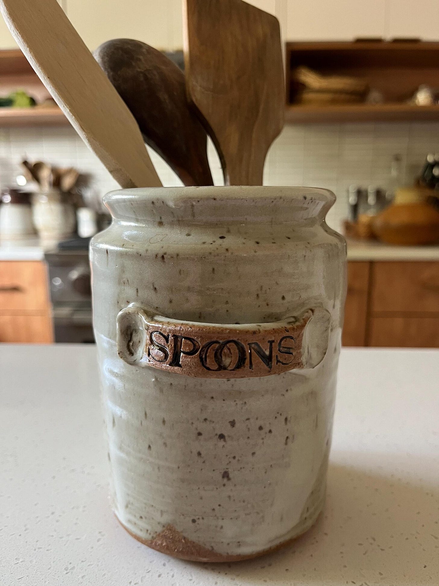 Utensil crock with SPOONS stamped on side.