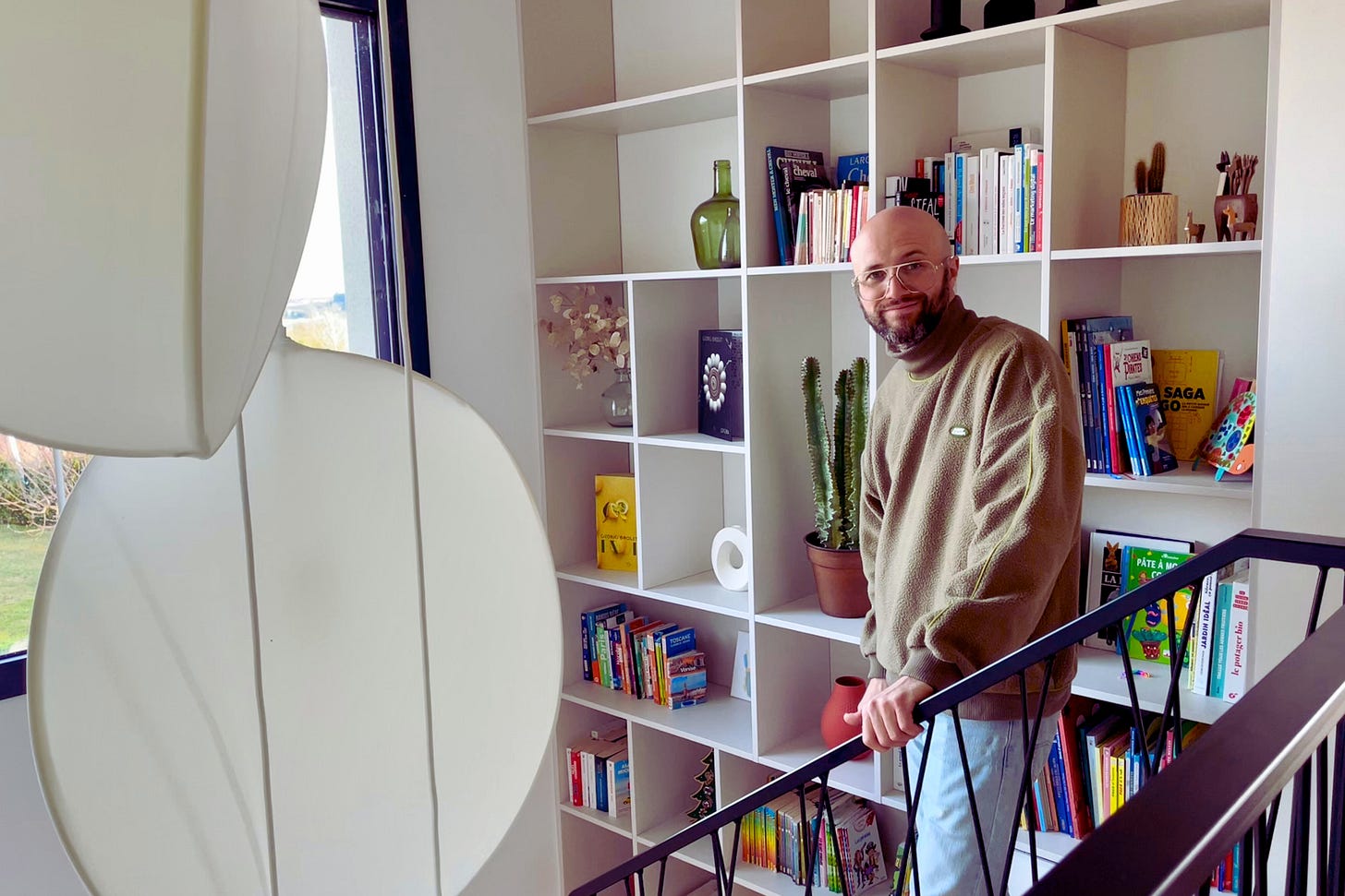 Photo de Yoann dans les escaliers, devant une bibliothèque Photo de Yoann dans les escaliers, devant une bibliothèque