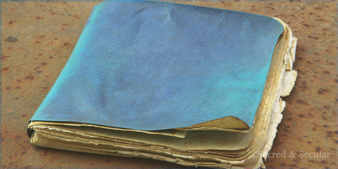 A weathered blue-covered notebook resting on an aged surface, its worn pages suggesting a story that has been lived over time and understood only in hindsight.