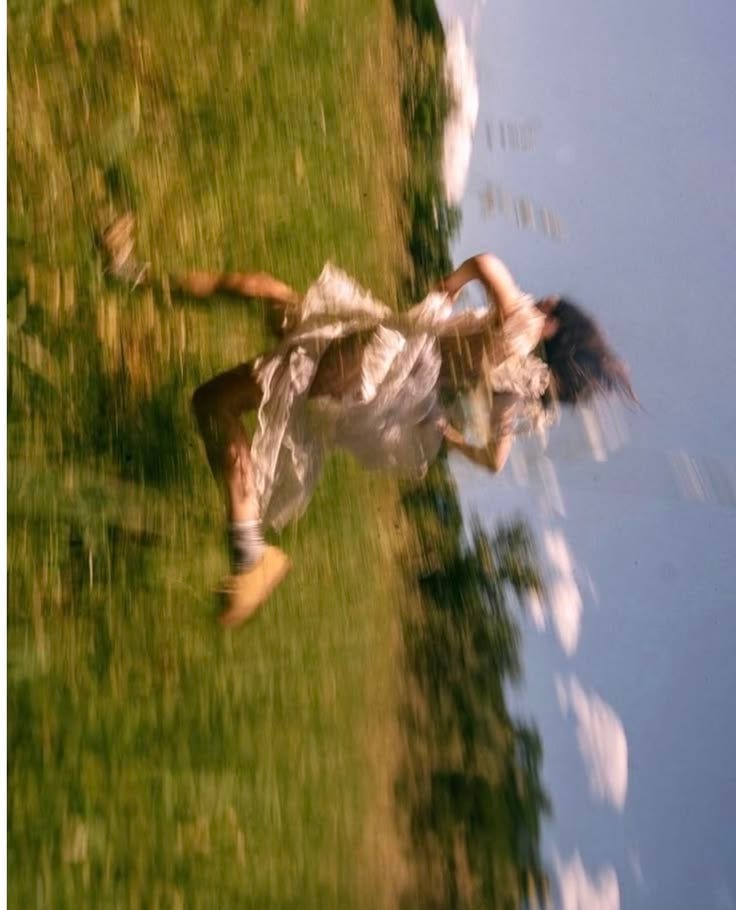 This may contain: a woman in a white dress is flying through the air