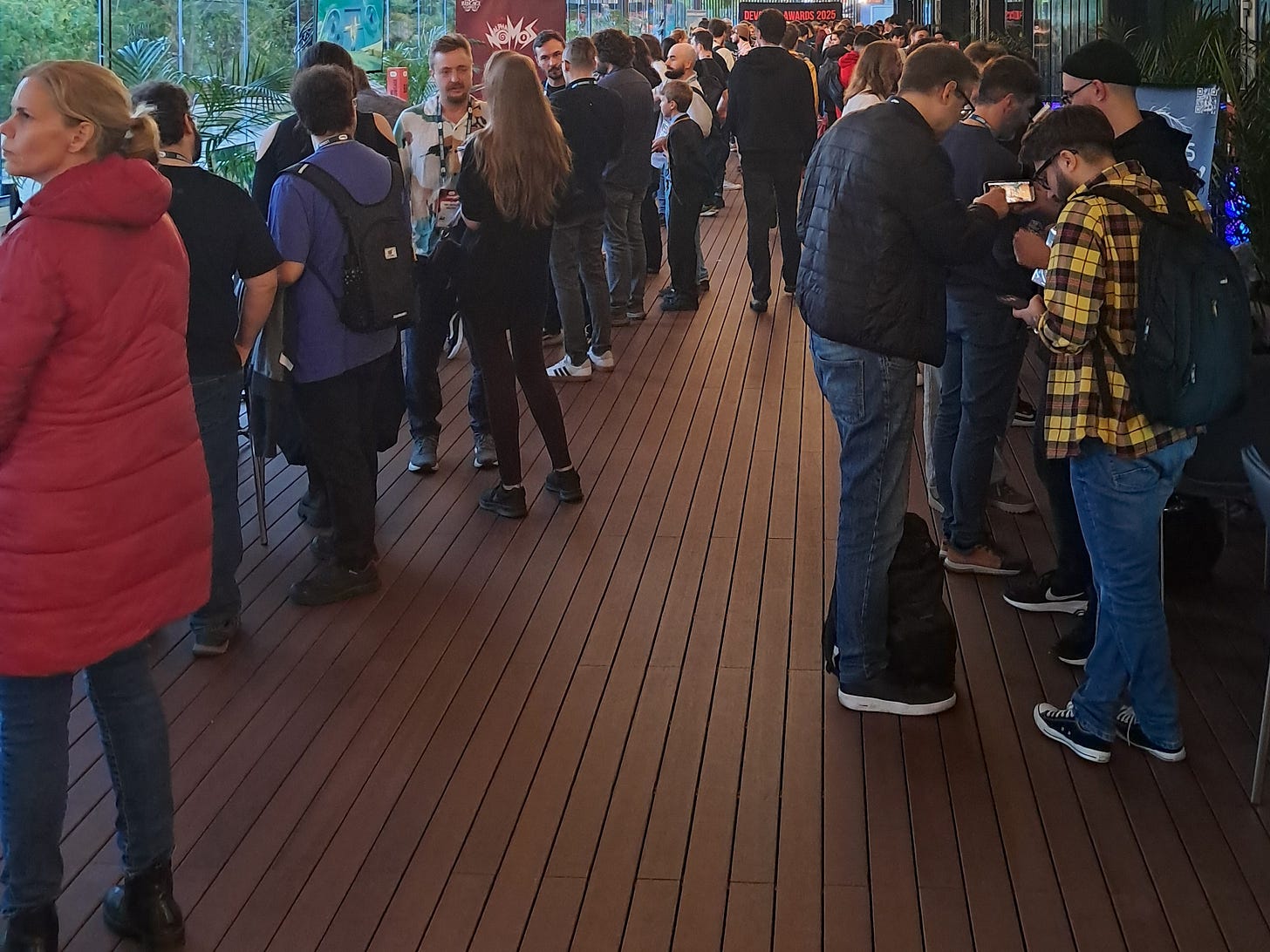 People grouping around computers at one of the two showcase areas at DevGAMM Lisbon 2025.