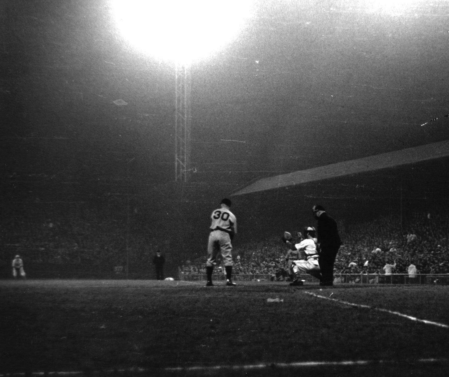 Ethan Allen stands in at bat under a massive light tower at Crosley Field.