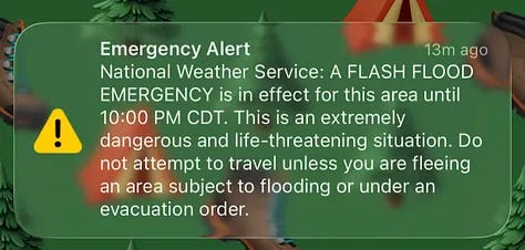 A train arriving, a emergency weather alert, rain on the window, sunset in the distance