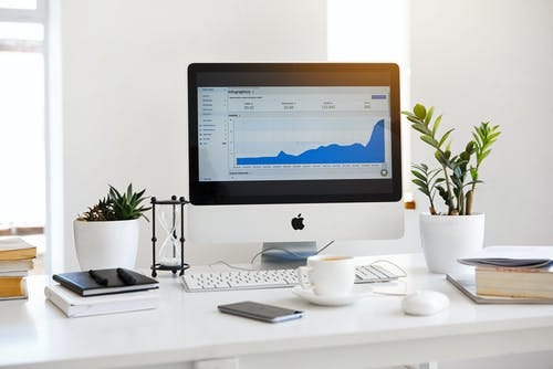 Silver Imac Displaying Line Graph Placed on Desk Silver Imac Displaying Line Graph Placed on Desk