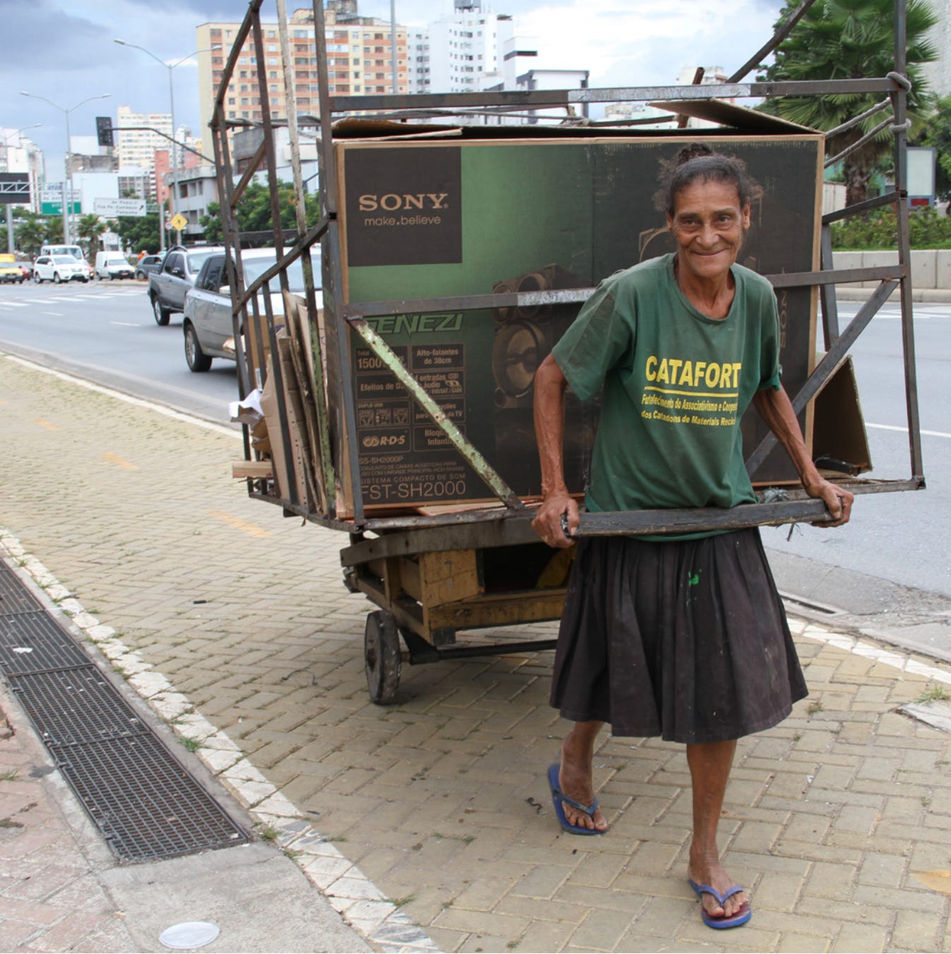 A catadora pulls a cart to collect what others have thrown away