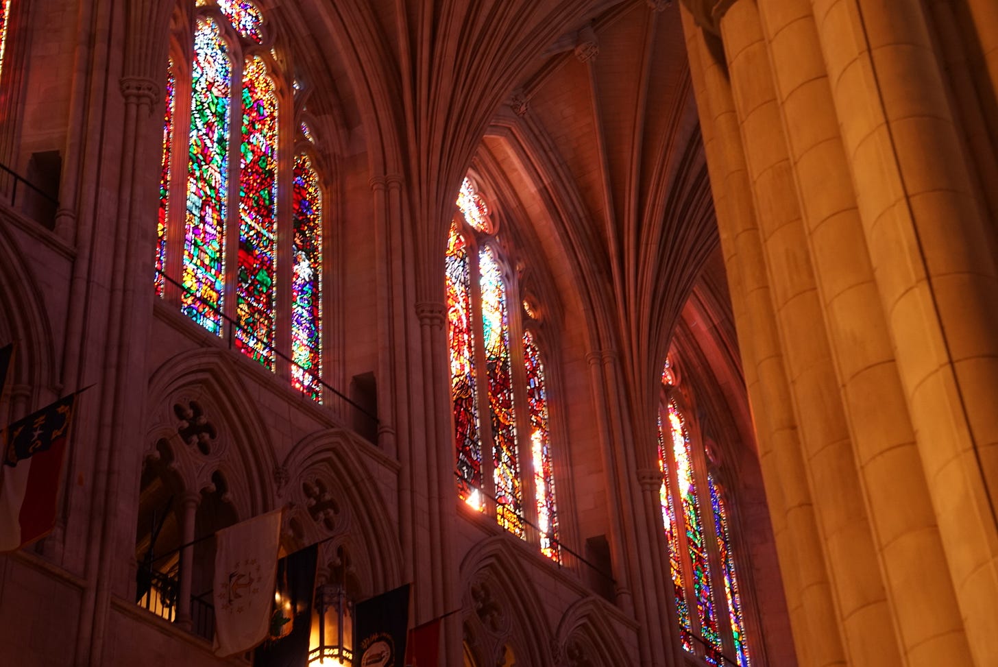 Cavernous stone columns and arches. Light flowing in through beautiful stained glass windows.