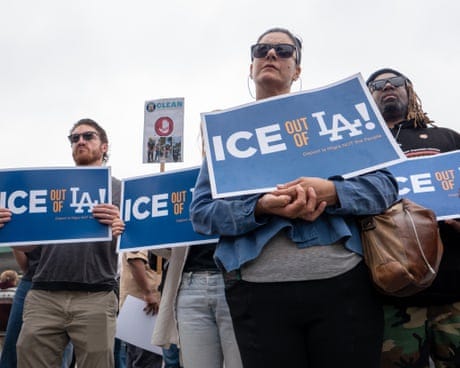 people hold signs that read 'ice out of LA' people hold signs that read 'ice out of LA'