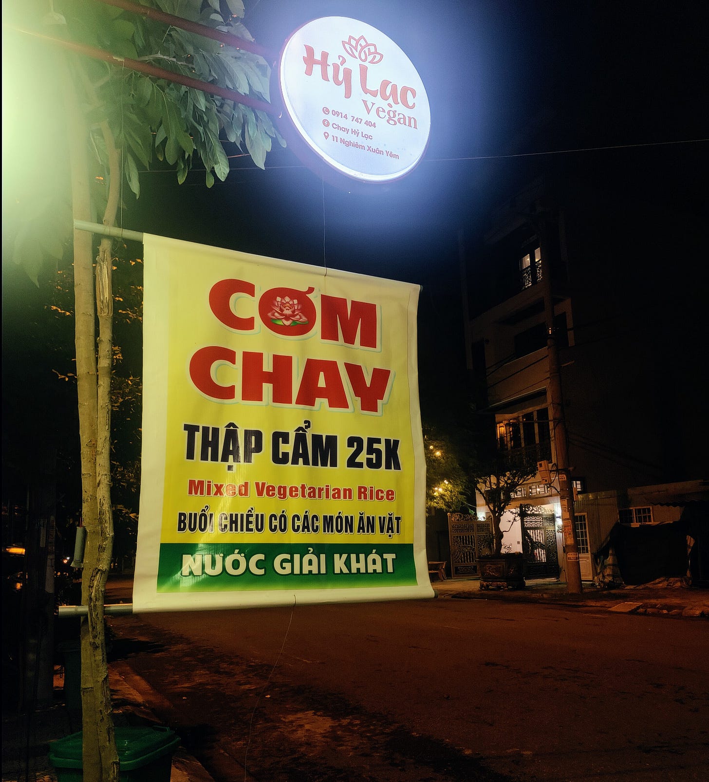 sign announcing Cơm chay thập cẩm at night