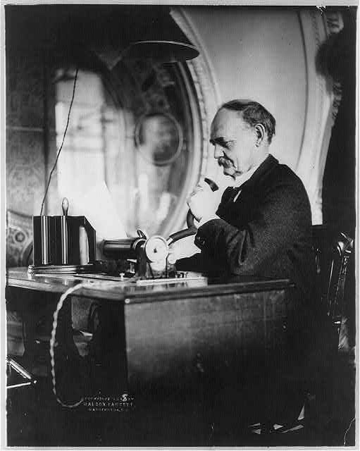black and white photo of a man speaking into a dictaphone black and white photo of a man speaking into a dictaphone