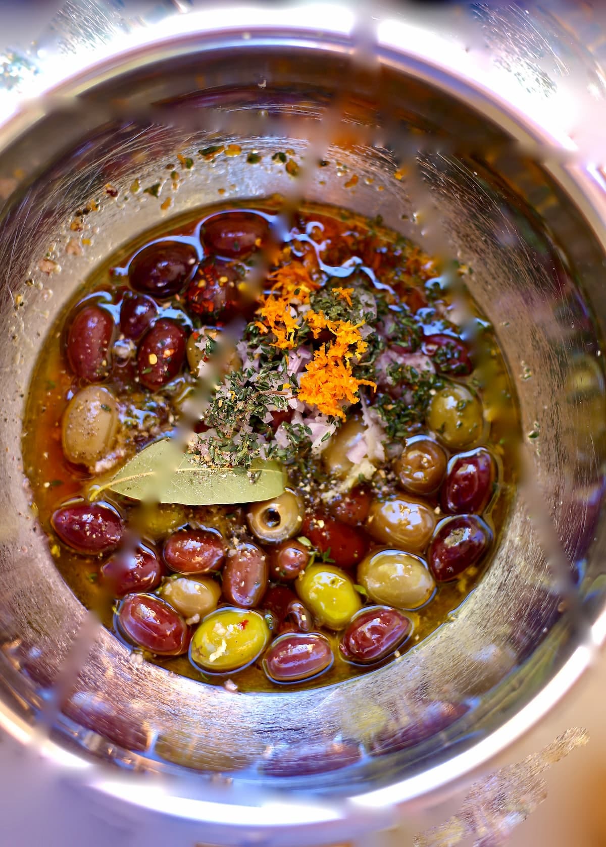 a bowl with seasonings and olives including thyme and bay leaf a bowl with seasonings and olives including thyme and bay leaf