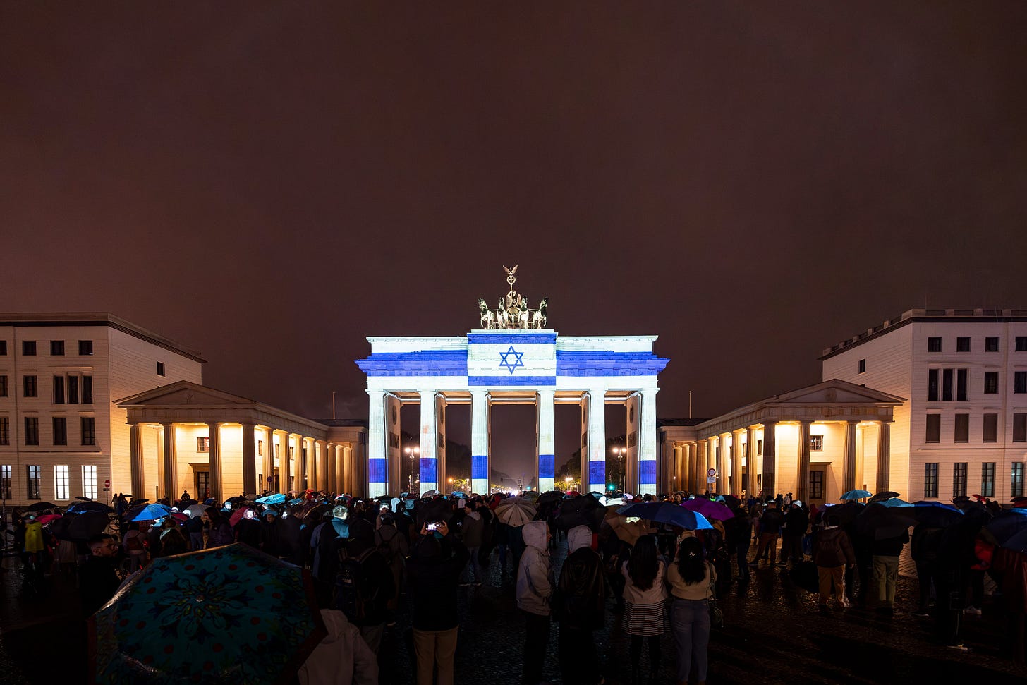 Das Foto zeigt das Brandenburger Tor in Berlin beleuchtet in den Farben der israelischen Flagge. 