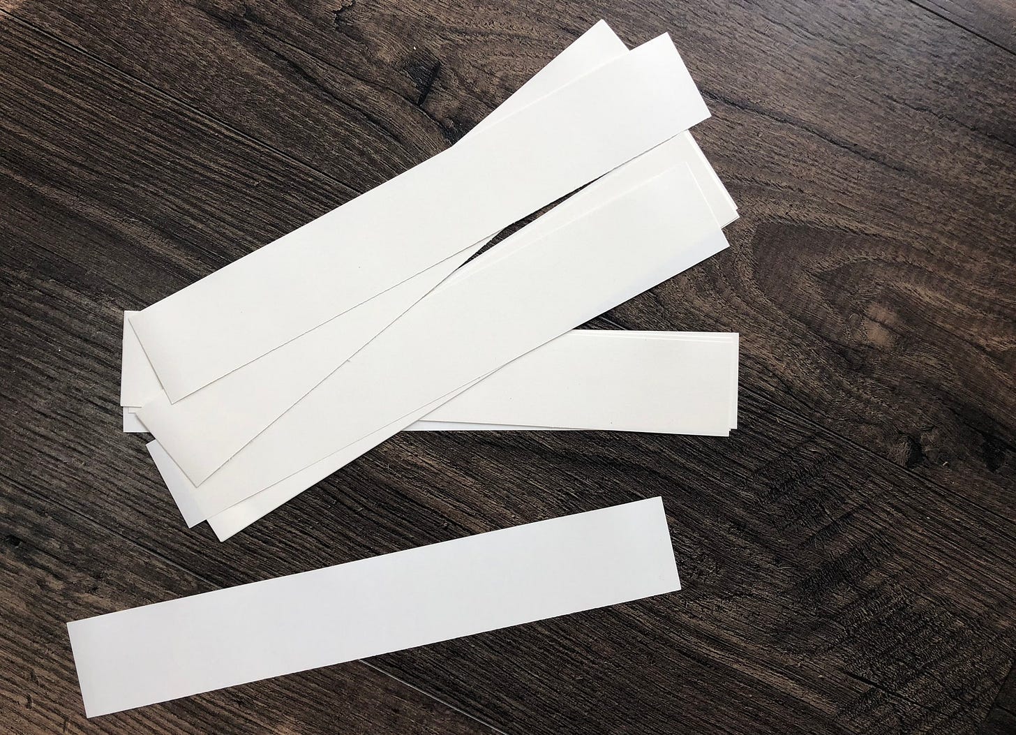 a pile of blank paper scraps on a wood floor