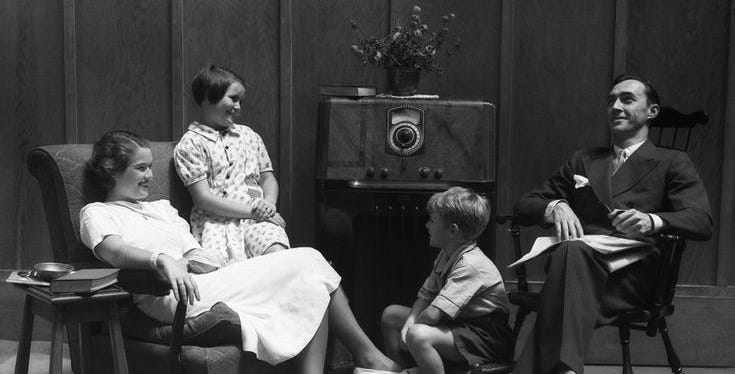 1930s family gathered around the radio. 1930s family gathered around the radio.