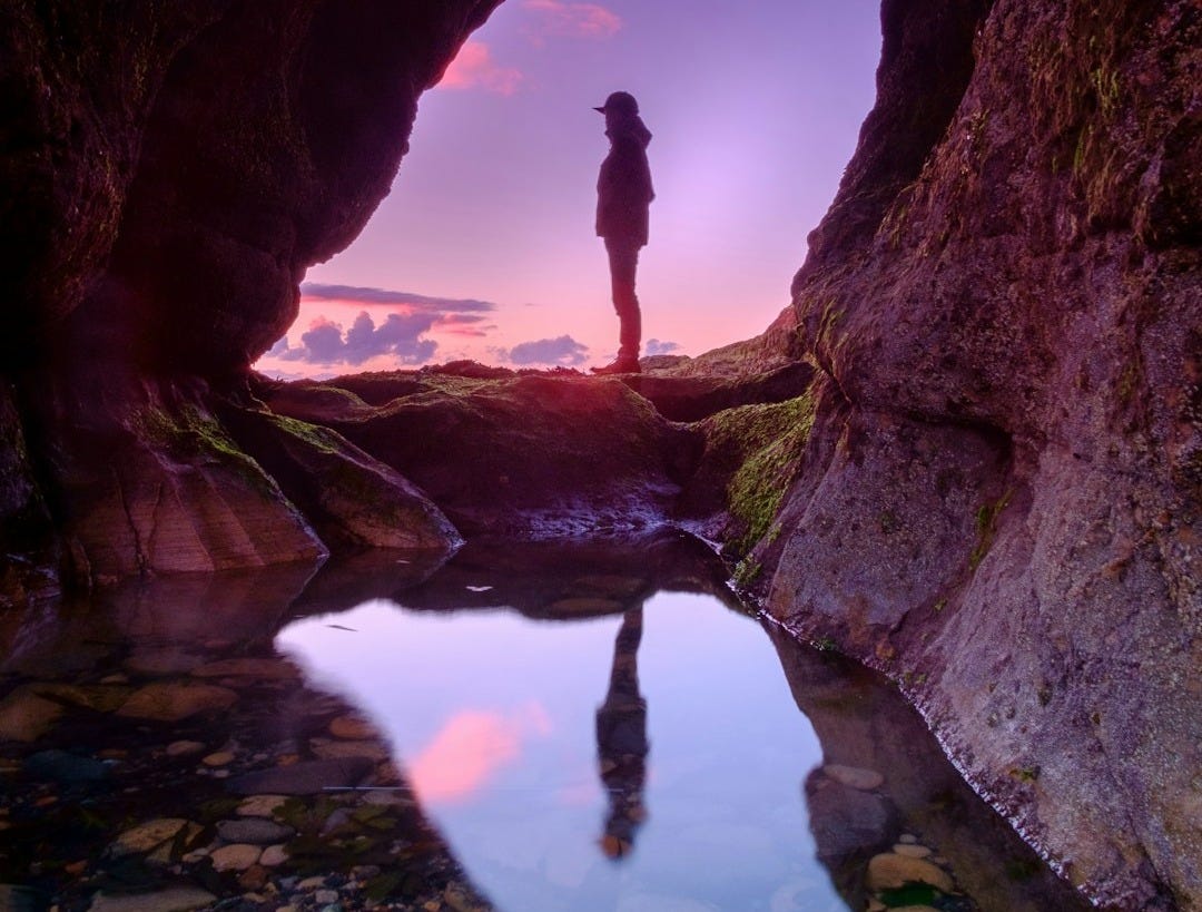 man standing in front of cave