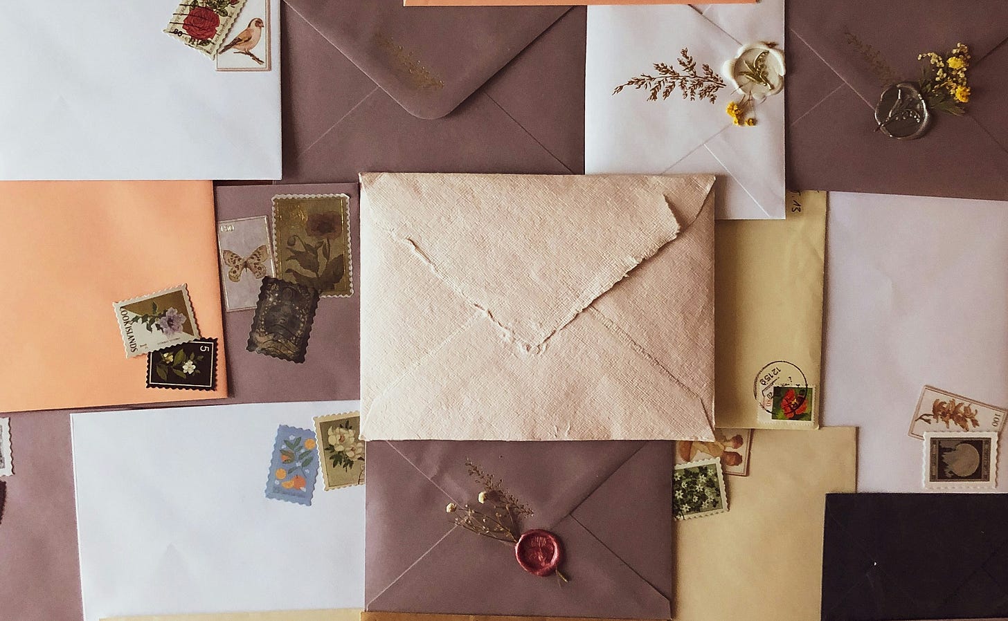 A spread of brown, orange, and white envelopes with a cream-colour envelope in the middle.