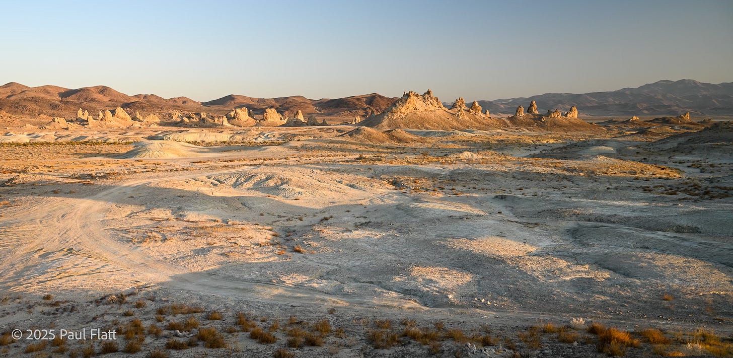 Broad expanse of desert with pinnacles in the distance.