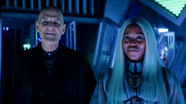 This image shows the gods of chaos Zellin (played by Ian Gelder, left) and Rakaya (played by Claire-Hope Ashitey, right) smiling as they look off-camera at the unseen, captive Thirteenth Doctor and friends. This image shows the gods of chaos Zellin (played by Ian Gelder, left) and Rakaya (played by Claire-Hope Ashitey, right) smiling as they look off-camera at the unseen, captive Thirteenth Doctor and friends.