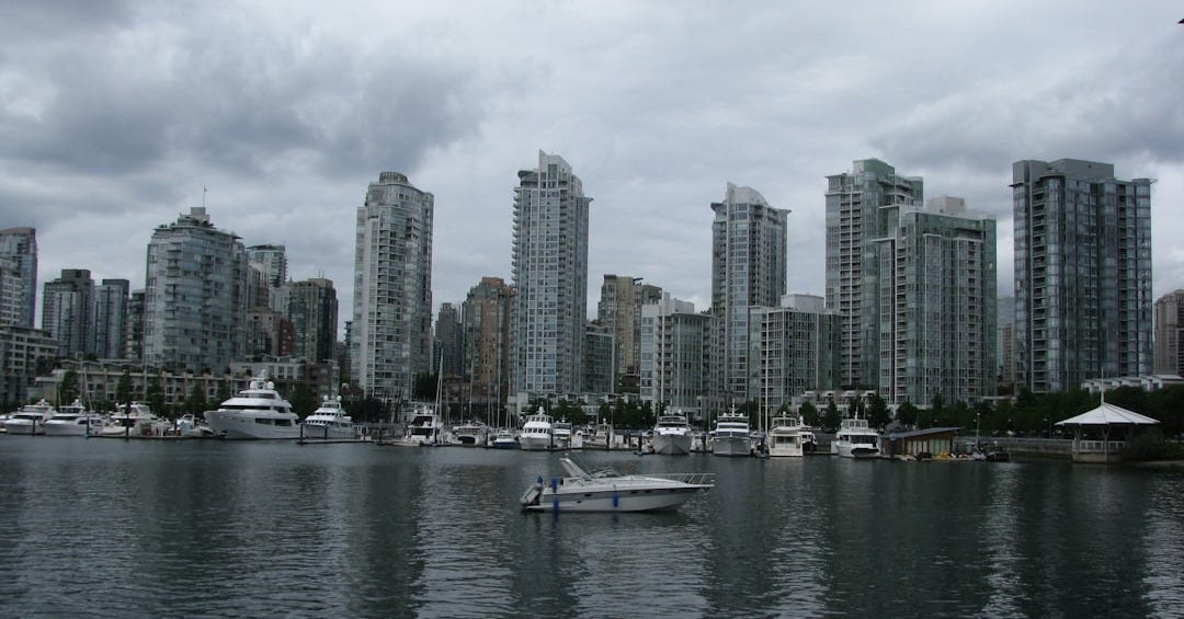 white boat on sea near city buildings during daytime