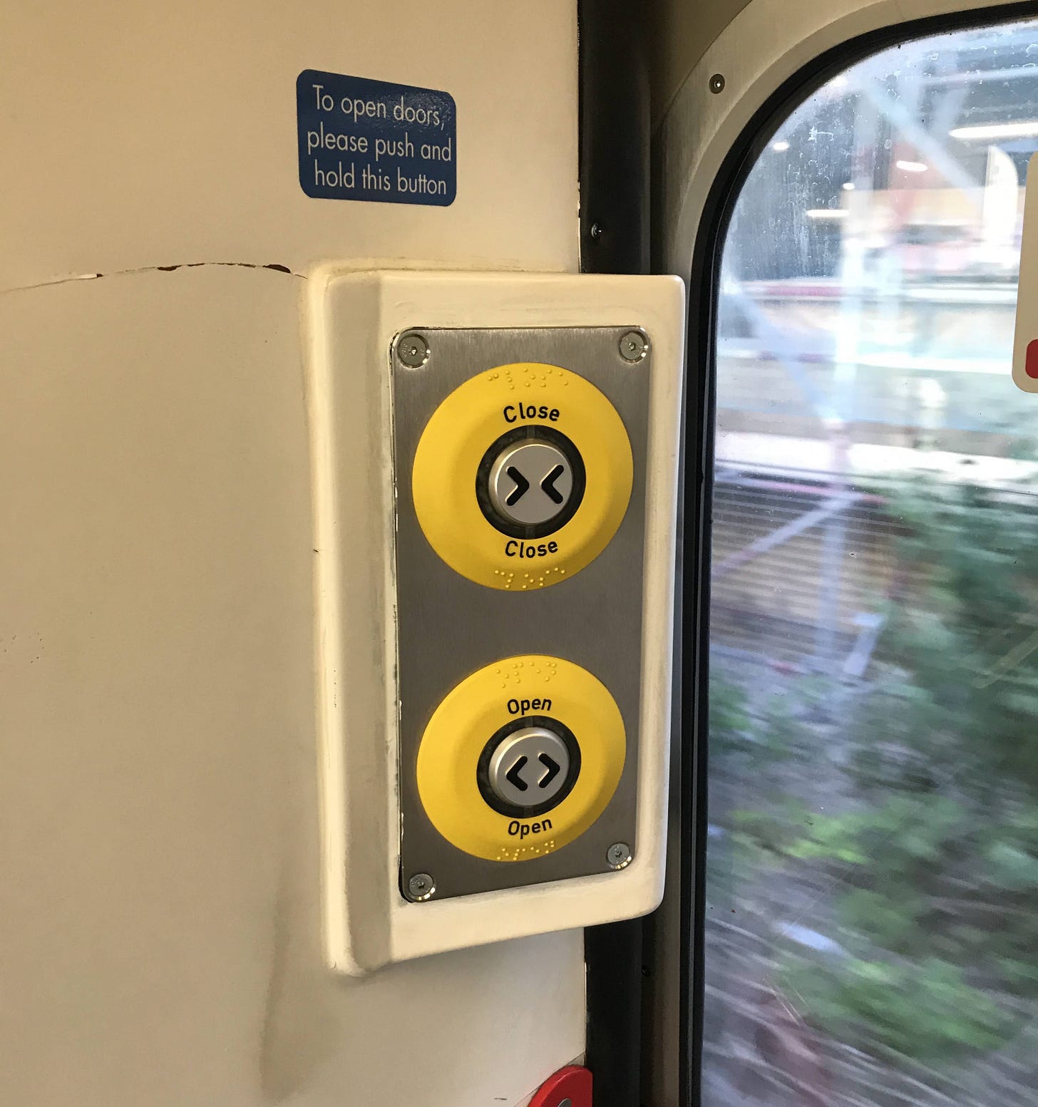 Photo of retrofitted door buttons on a Class 317 train.